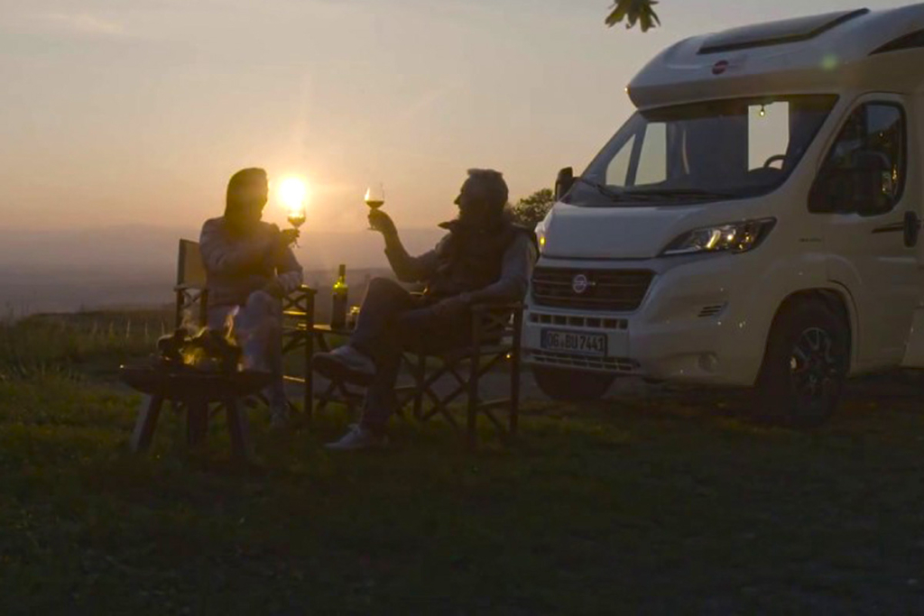 El placer de un nómada moderno, Autocaravana, vino y atardecer
